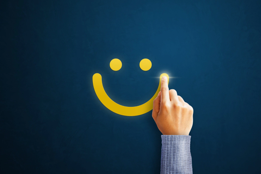 Une équipe à l’écoute de ses clients main qui dessine un smiley jaune